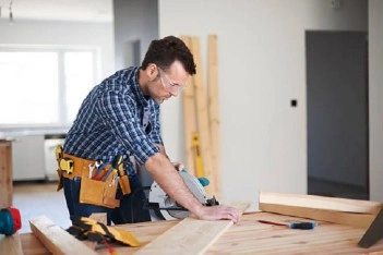 About People Helping People carpenter cutting wood boards