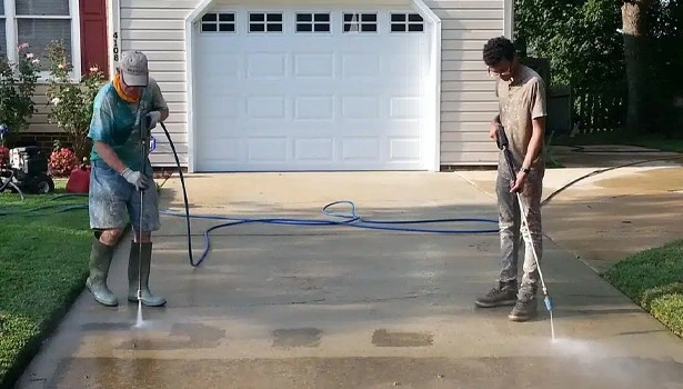 About People Helping People workers pressure washing driveway