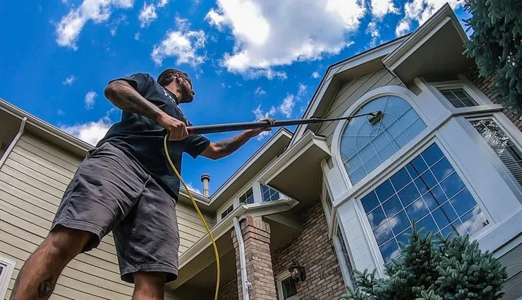 About People Helping People worker soft washing upper home exterior
