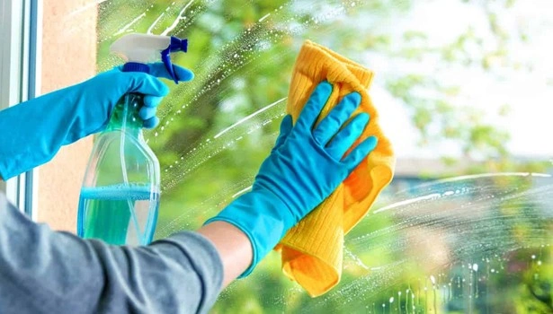 About People Helping People hand spraying and wiping a glass window