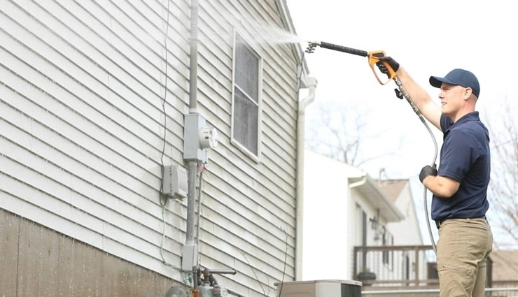 About People Helping People worker washing vinyl siding
